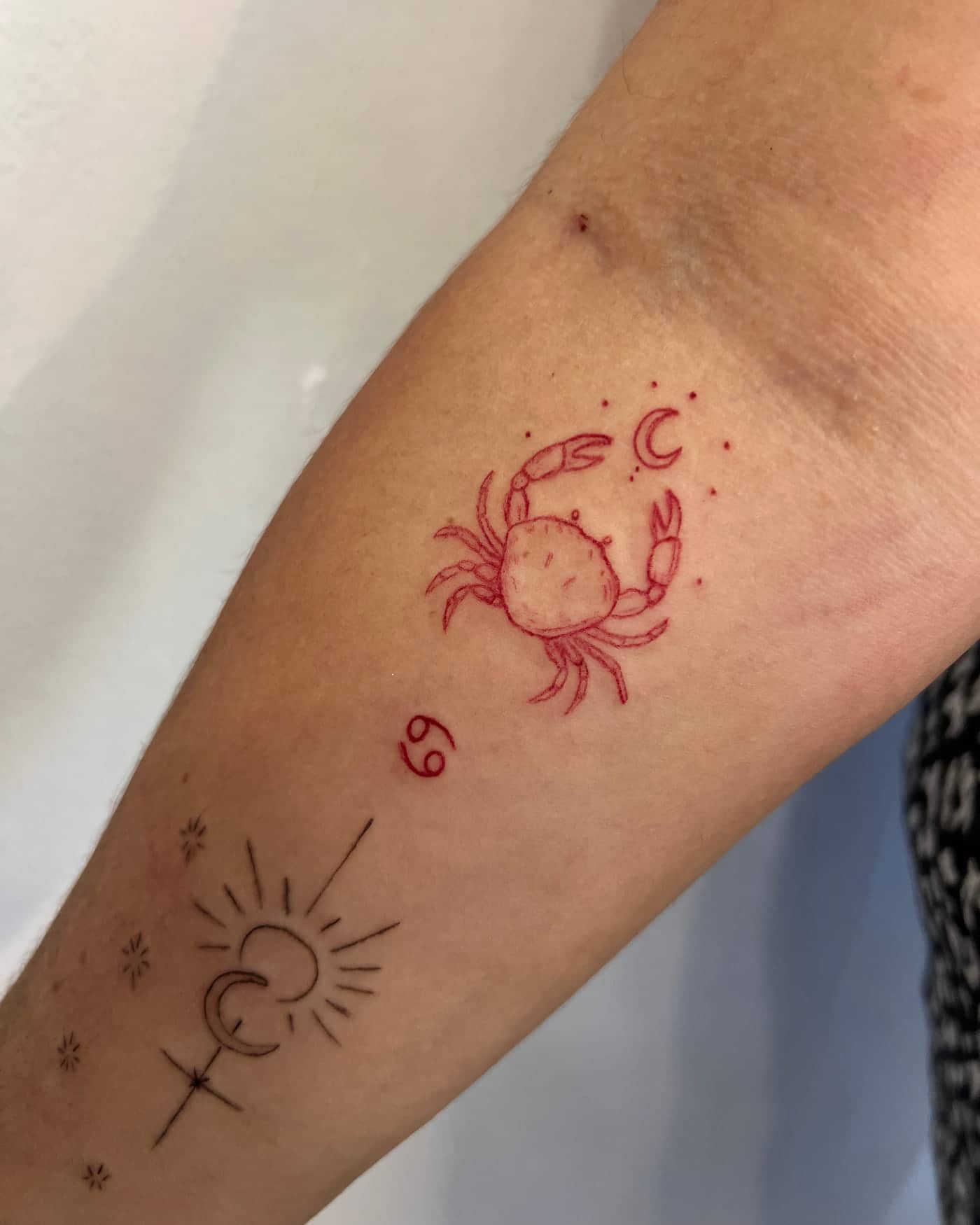 Red fine line Cancer crab tattoo with moon, stars and zodiac symbol